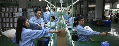 Factoryline workers producing artists Cohen van Balen's useless object.
