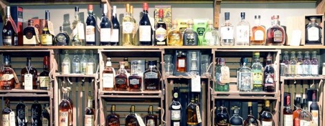 Photograph of shelves stacked with bottles of spirit.