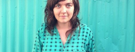 Singer Courtney Barnet in a turquoise shirt against a turquoise background