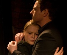 Photo of a man and a woman embracing against a black background