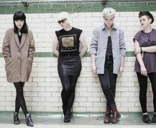 Photo of PINS band against a white and green tiled wall.