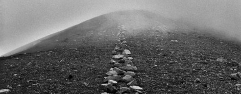 Black and white image of a Richard Long art piece; stones leading into mist.