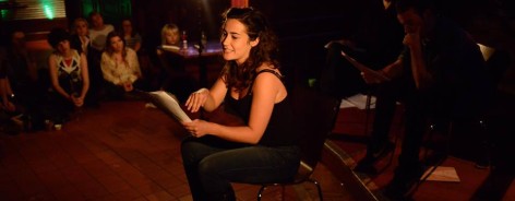 A woman reads from the page at the spring scratch night