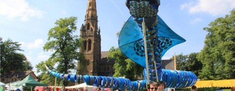 Photo of a giant puppet snake being manipulated by dozens of people.