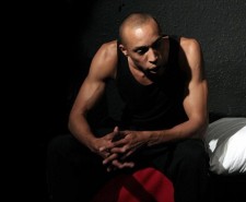 Photo of the actor playing Len Johnson, sat with his hands on one knee