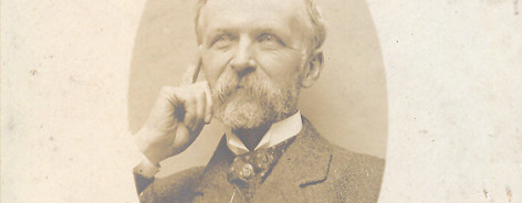 Sepia photo of Henry Watson with beard and moustache, hand on chin