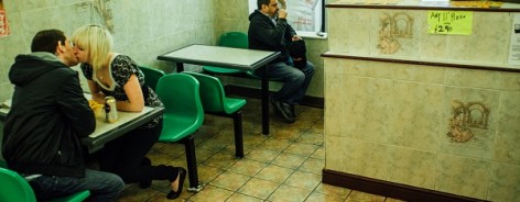 Photo of a couple kissing in a takeaway pizza place in Leeds.