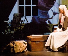 Photo of a woman in a nurse's outfit sitting amongst boxes