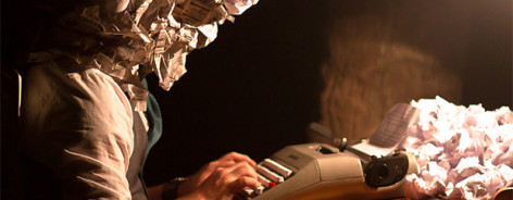 image of a man at a typewriter with balls of paper for a head