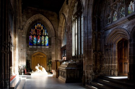 Photo of one aisle with stained glass windows at the end