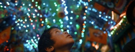 A child looks up at bright lights