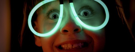 Photo of a kid wearing glow stick glasses