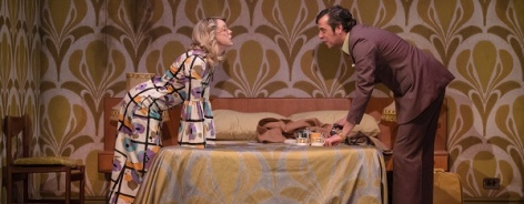 Photo of a man and a woman on either side of a bed