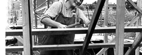Black and white photo of a woman working on a building site