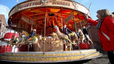 Woman waves to kids on carousel