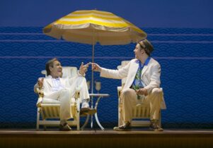 Robert Lindsay and Rufus Hound in Dirty Rotten Scoundrels - on beach chairs beneath a yellow umbrella