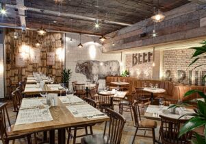 Photograph of Beef and Pudding's interior, with a bull printed on white tiles on the back wall