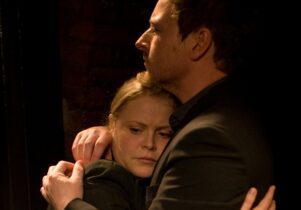 Photo of a man and a woman embracing against a black background