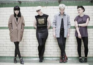 Photo of PINS band against a white and green tiled wall.