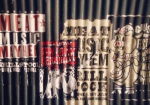 Posters on corrugated iron, advertising Grillstock.