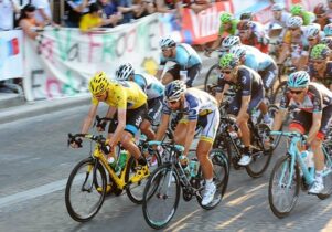 Photo of cyclists on the Tour de France, a man in front with a yellow helmet and jersey