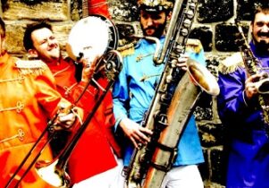Colourful photo of a band in coloured jackets, holding their instruments