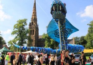 Photo of a giant puppet snake being manipulated by dozens of people.