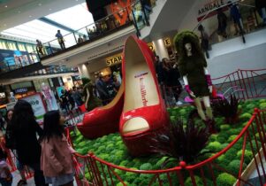 Photo of Frog Flowers' Dig the City installation at the Arndale Centre, with an enormous pair of red shoes
