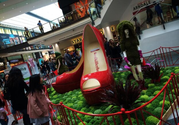 Photo of Frog Flowers' Dig the City installation at the Arndale Centre, with an enormous pair of red shoes