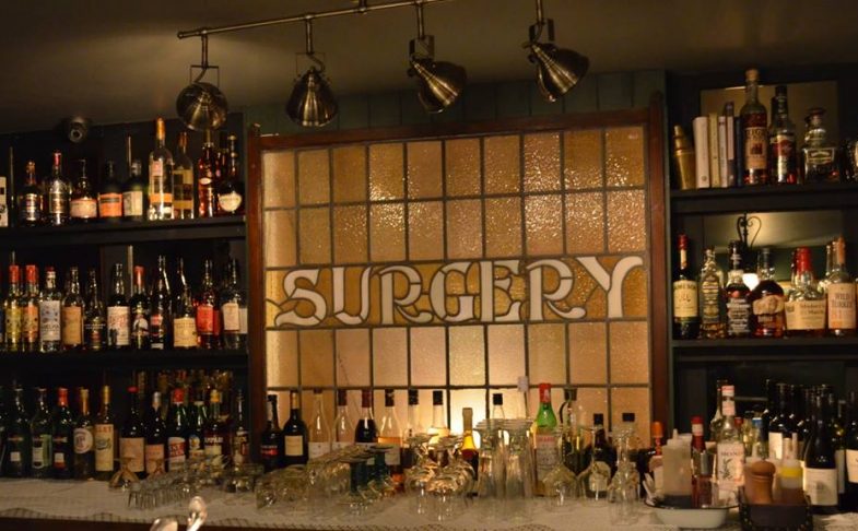 Photo of a stained glass window showing the word 'Surgery'