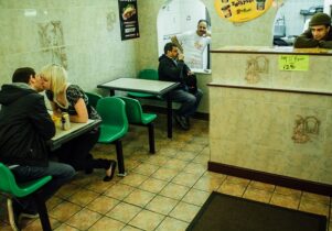 Photo of a couple kissing in a takeaway pizza place in Leeds.