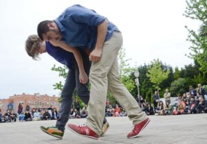 Photo of two dancers bent forwards in the same position