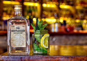 Photo of a bottle of 'Bootlegger' white grain spirit next to a jar with mint
