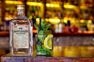 Photo of a bottle of 'Bootlegger' white grain spirit next to a jar with mint