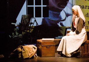 Photo of a woman in a nurse's outfit sitting amongst boxes
