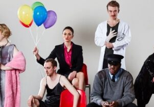 Photo of the cast dressed up, with a bunch of balloons