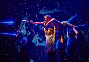 Photo from the production, with Christopher being carried