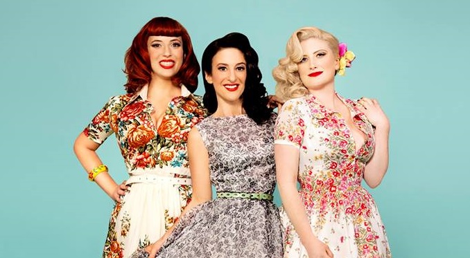 Phot0 of the 3 Puppini Sisters agains a teal background