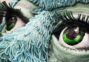Giant eyes of a blue-haired puppet
