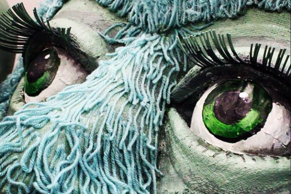 Giant eyes of a blue-haired puppet