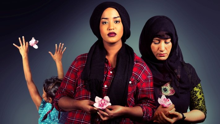 Three women hold flowers in their hands