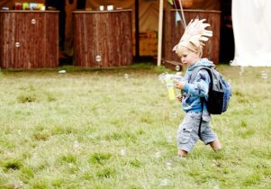 Small boy with bubble blower and headdress