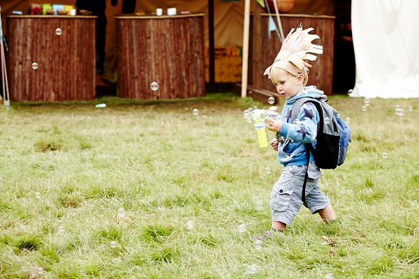 Small boy with bubble blower and headdress