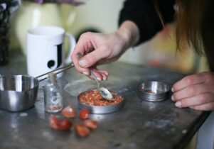 Photo of Jade's hands spooning stones in her studio