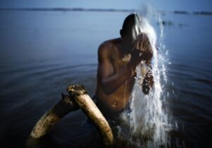 Man washes face in lake