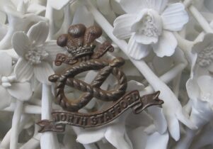 Photo of white bone china flowers and a medal