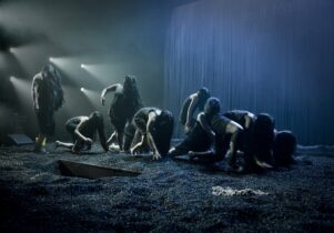 Photo of the Furies climbing across stage