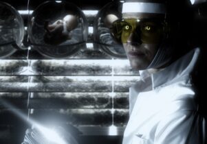 A woman in a white coat with yellow glasses