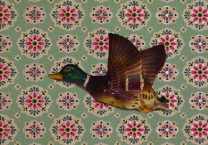A flying duck on paisley wallpaper