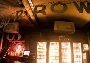 A sign for a Burrow above a bar